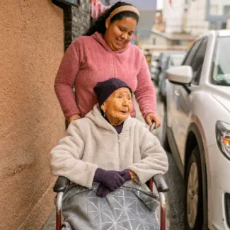 woman assisting senior in wheelchair