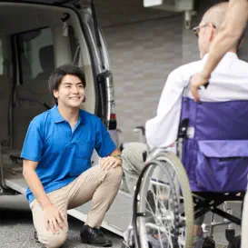 man assisting senior in wheelchair