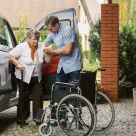 man assisting senior in wheelchair