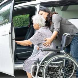 woman assisting senior in wheelchair