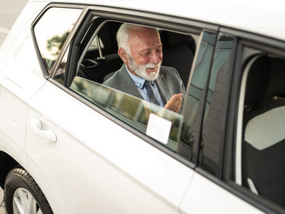 senior inside the vehicle smiling