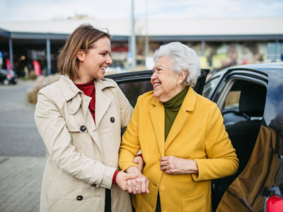 woman assisting senior from vehicle
