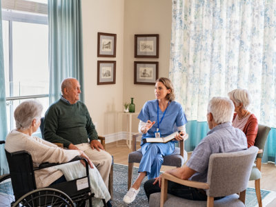 Nurse talking to senior people during group therapy 