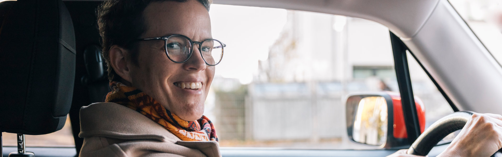 woman driving vehicle smiling